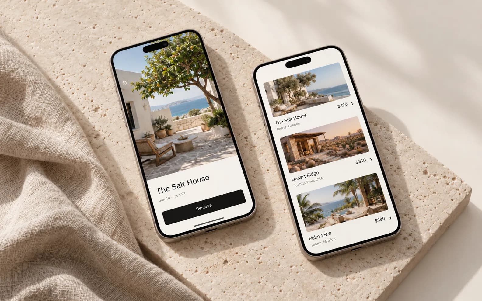 Two phones showing the Maison booking app on a travertine slab